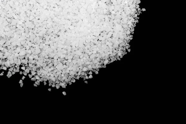 Siyah arka plana beyaz deniz tuzu döküldü. Siyah arkaplanda şeffaf çakıl taşları