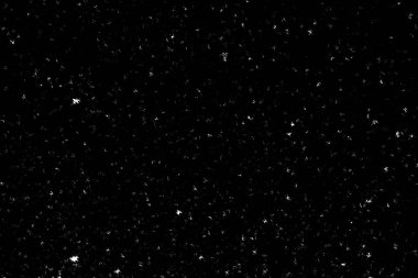 Siyah arka planda beyaz lekeler ve izler var. Beyaz bulanıklık ve dalgalanmalar. Kar yağışı, soyutlama