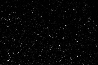 Siyah arka planda beyaz lekeler ve izler var. Beyaz bulanıklık ve dalgalanmalar. Kar yağışı, soyutlama