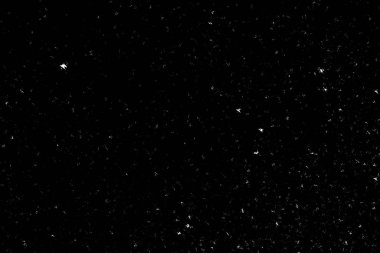 Siyah arka planda beyaz lekeler ve izler var. Beyaz bulanıklık ve dalgalanmalar. Kar yağışı, soyutlama