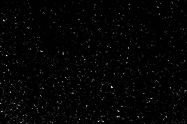 White spots and marks on a black background. white blur and ripples. snowfall, abstraction