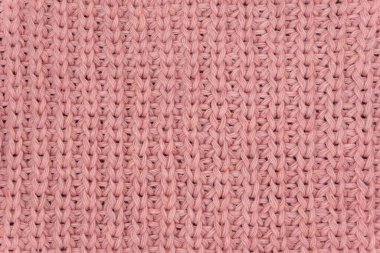 Pembe örülmüş süveterin dokusu yakından, kırmızı örülmüş yün.