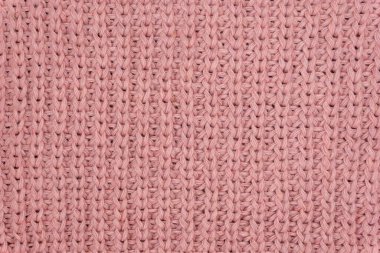 Pembe örülmüş süveterin dokusu yakından, kırmızı örülmüş yün.