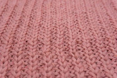 Pembe örülmüş süveterin dokusu yakından, kırmızı örülmüş yün.