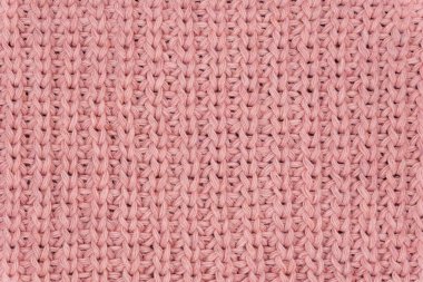 Pembe örülmüş süveterin dokusu yakından, kırmızı örülmüş yün.