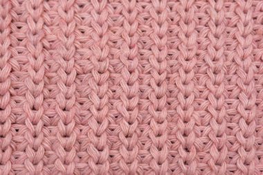 Pembe örülmüş süveterin dokusu yakından, kırmızı örülmüş yün.