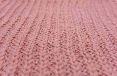 Pembe örülmüş süveterin dokusu yakından, kırmızı örülmüş yün.