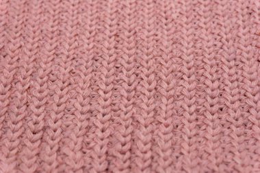 Pembe örülmüş süveterin dokusu yakından, kırmızı örülmüş yün.