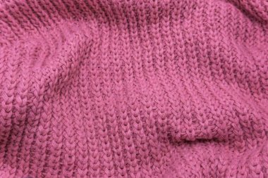 Pembe örülmüş süveterin dokusu, yakın plan, kırmızı örgü yün.