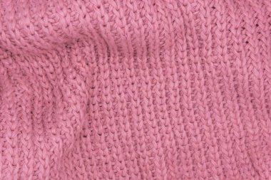 Pembe örülmüş süveterin dokusu, yakın plan, kırmızı örgü yün.