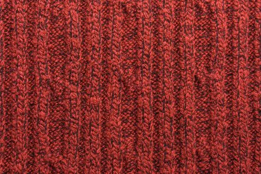 Kırmızı örülmüş süveterin dokusu yakın plan. Örgü yün malzeme.