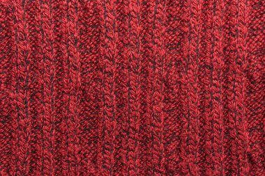Kırmızı örülmüş süveterin dokusu yakın plan. Örgü yün malzeme.