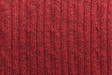 Kırmızı örülmüş süveterin dokusu yakın plan. Örgü yün malzeme.