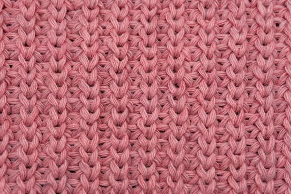 Pembe örülmüş süveterin dokusu yakından, kırmızı örülmüş yün.