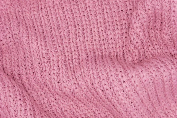 Pembe örülmüş süveterin dokusu, yakın plan, kırmızı örgü yün.
