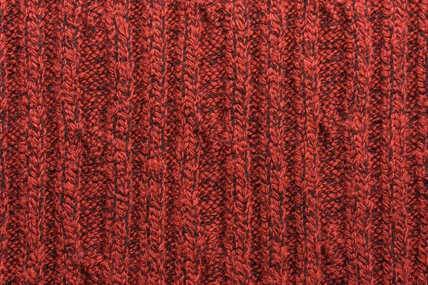 Kırmızı örülmüş süveterin dokusu yakın plan. Örgü yün malzeme.