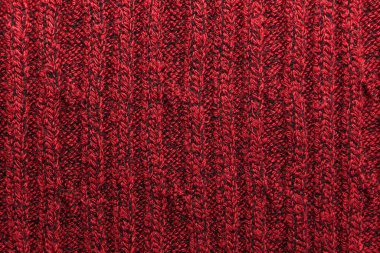 Kırmızı örülmüş süveterin dokusu yakın plan. Örgü yün malzeme.