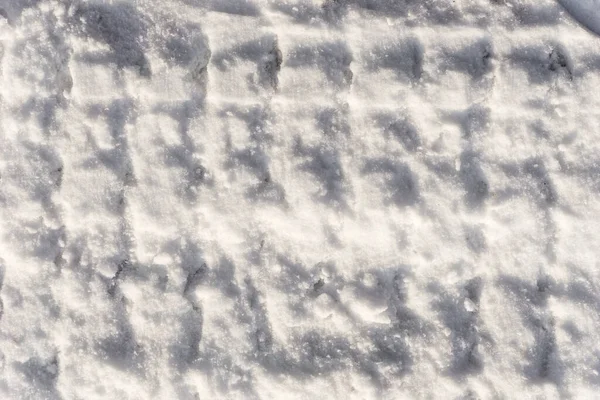 白い雪の質感 青のトーンで新鮮な雪のテクスチャの背景 雪の背景に車のプロテクターの痕跡 雪の上のパターン — ストック写真