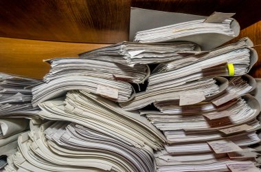 Arşivde birikmiş eski kağıt belgeler. Belgeler arşiv odasının raflarında. Ofis rafları dosyalarla dolu dolapta.