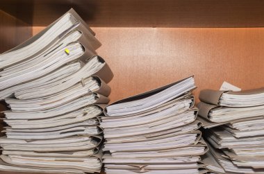 Arşivde birikmiş eski kağıt belgeler. Belgeler arşiv odasının raflarında. Ofis rafları dosyalarla dolu dolapta.