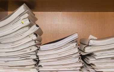 Arşivde birikmiş eski kağıt belgeler. Belgeler arşiv odasının raflarında. Ofis rafları dosyalarla dolu dolapta.