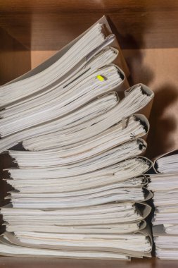 Arşivde birikmiş eski kağıt belgeler. Belgeler arşiv odasının raflarında. Ofis rafları dosyalarla dolu dolapta.