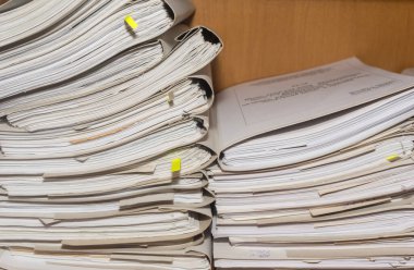 Arşivde birikmiş eski kağıt belgeler. Belgeler arşiv odasının raflarında. Ofis rafları dosyalarla dolu dolapta.