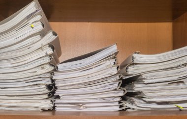 Arşivde birikmiş eski kağıt belgeler. Belgeler arşiv odasının raflarında. Ofis rafları dosyalarla dolu dolapta.