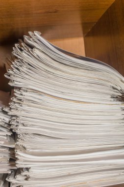 Arşivde birikmiş eski kağıt belgeler. Belgeler arşiv odasının raflarında. Ofis rafları dosyalarla dolu dolapta.