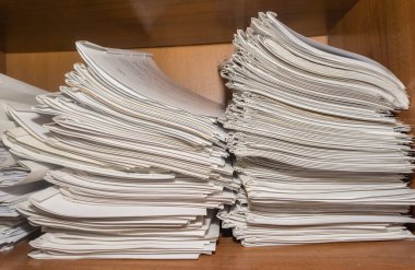 Arşivde birikmiş eski kağıt belgeler. Belgeler arşiv odasının raflarında. Ofis rafları dosyalarla dolu dolapta.