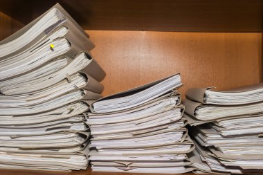 Arşivde birikmiş eski kağıt belgeler. Belgeler arşiv odasının raflarında. Ofis rafları dosyalarla dolu dolapta.