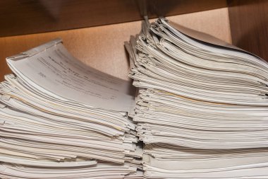 Arşivde birikmiş eski kağıt belgeler. Belgeler arşiv odasının raflarında. Ofis rafları dosyalarla dolu dolapta.