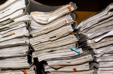 Arşivde birikmiş eski kağıt belgeler. Belgeler arşiv odasının raflarında. Ofis rafları dosyalarla dolu dolapta.