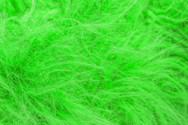 Yeşil kabarık yün dokusu, hayvan yünü arka planı, boyanmış kürk dokusu yakın plan.