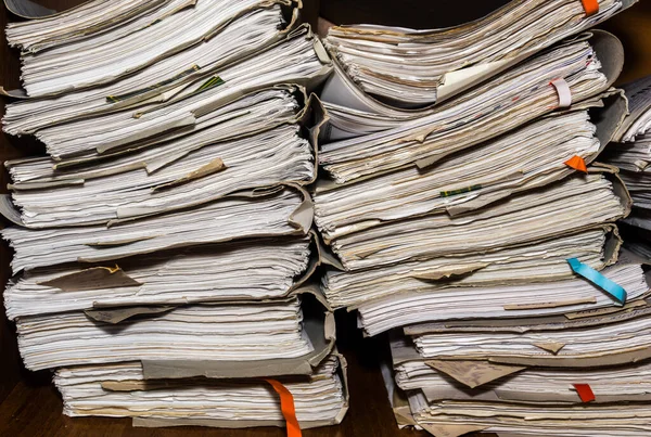 Old paper documents stacked in archive. Documents on the shelves of archive room. Office shelves in the closet full of files