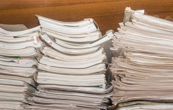 Arşivde birikmiş eski kağıt belgeler. Belgeler arşiv odasının raflarında. Ofis rafları dosyalarla dolu dolapta.