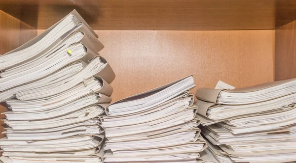 Arşivde birikmiş eski kağıt belgeler. Belgeler arşiv odasının raflarında. Ofis rafları dosyalarla dolu dolapta.