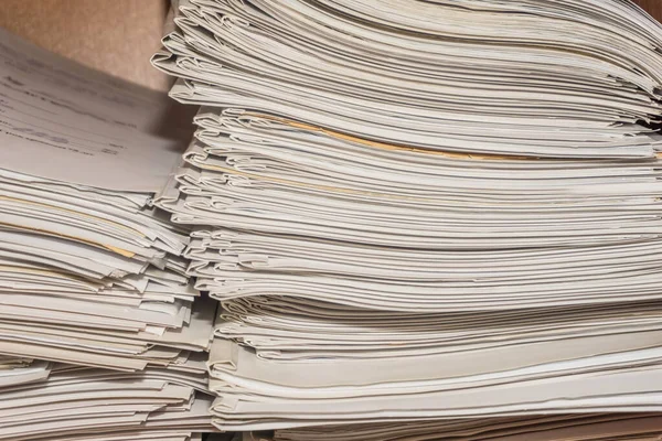 Arşivde birikmiş eski kağıt belgeler. Belgeler arşiv odasının raflarında. Ofis rafları dosyalarla dolu dolapta.