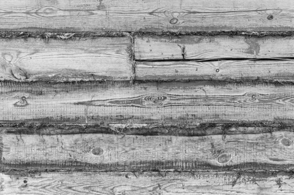 Gray wooden house wall made of wooden boards and panels with black paint background, wooden wall of building house, gray wooden fence of planks