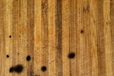 Arka planda çizikler olan eski ahşap tahta, yanmış lekeli kahverengi tahta, ahşap doku, hasarlı ahşap yüzey.