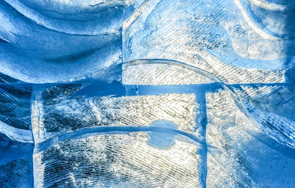 blue ice texture with a pattern and cracks background, ice frozen rink winter background, texture of ice surface, sunlit ice blocks texture, frozen water