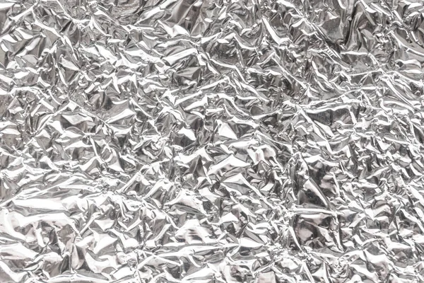 Silver wrinkled food foil background texture, crumpled aluminum foil, abstract shiny background