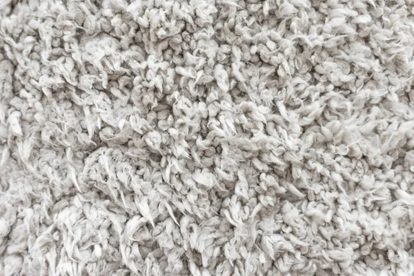 White wool texture background,  light natural sheep wool, texture of white fluffy fur, fragment  wool carpet, gray mat, white rug