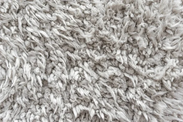 White wool texture background,  light natural sheep wool, texture of white fluffy fur, fragment  wool carpet, gray mat, white rug
