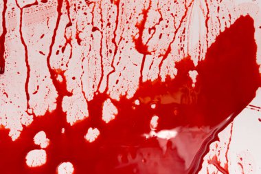 Beyaz arka planda kanlı sıçramalar ve damlalar. Damlayan ve takip eden kırmızı kan (boya)