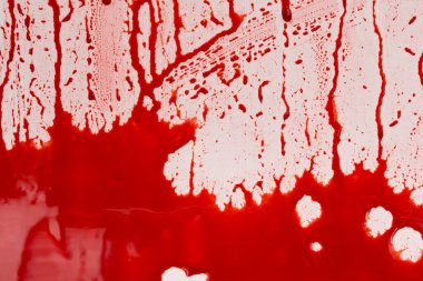 Beyaz arka planda kanlı sıçramalar ve damlalar. Damlayan ve takip eden kırmızı kan (boya)