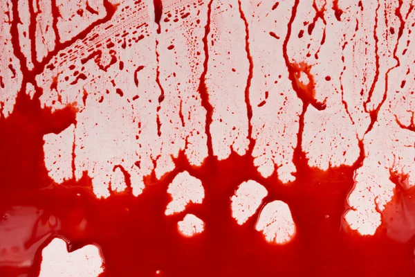 Beyaz arka planda kanlı sıçramalar ve damlalar. Damlayan ve takip eden kırmızı kan (boya)