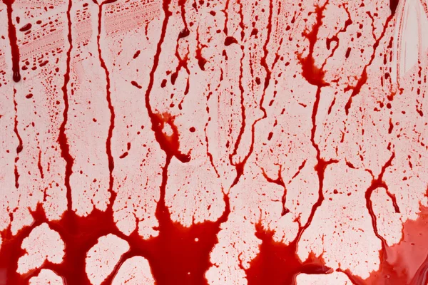 Beyaz arka planda kanlı sıçramalar ve damlalar. Damlayan ve takip eden kırmızı kan (boya)