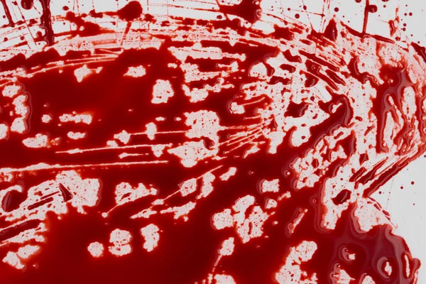 Beyaz arka planda kanlı sıçramalar ve damlalar. Damlayan ve takip eden kırmızı kan (boya)