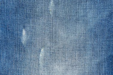 Delik desenli arka planı olan yırtık mavi kot pantolon